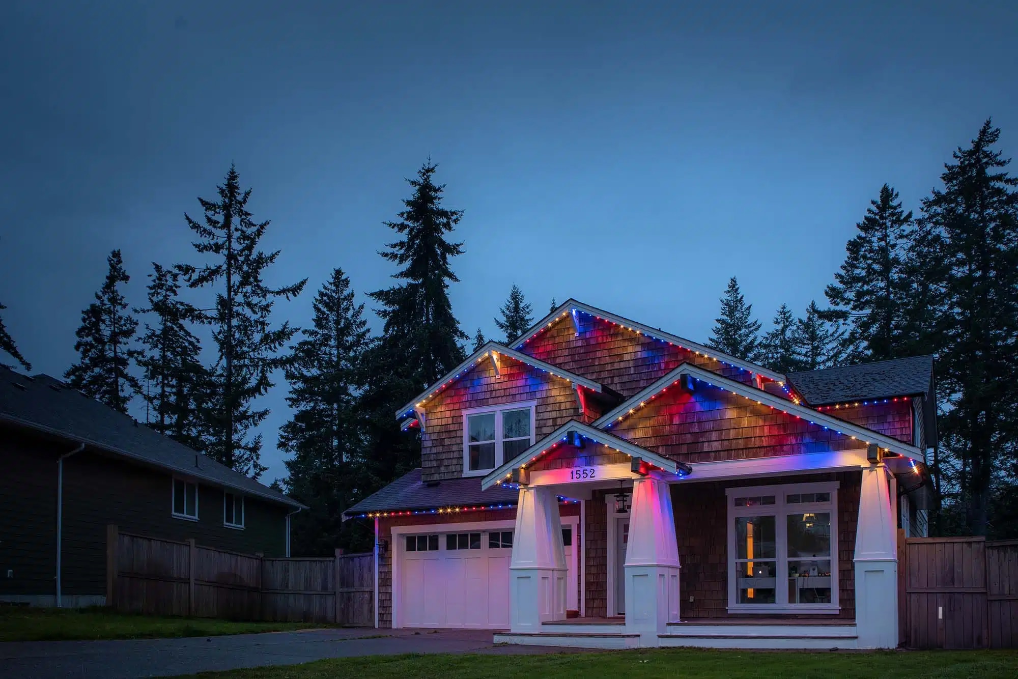 Craftsman home with red and blue architectural lighting