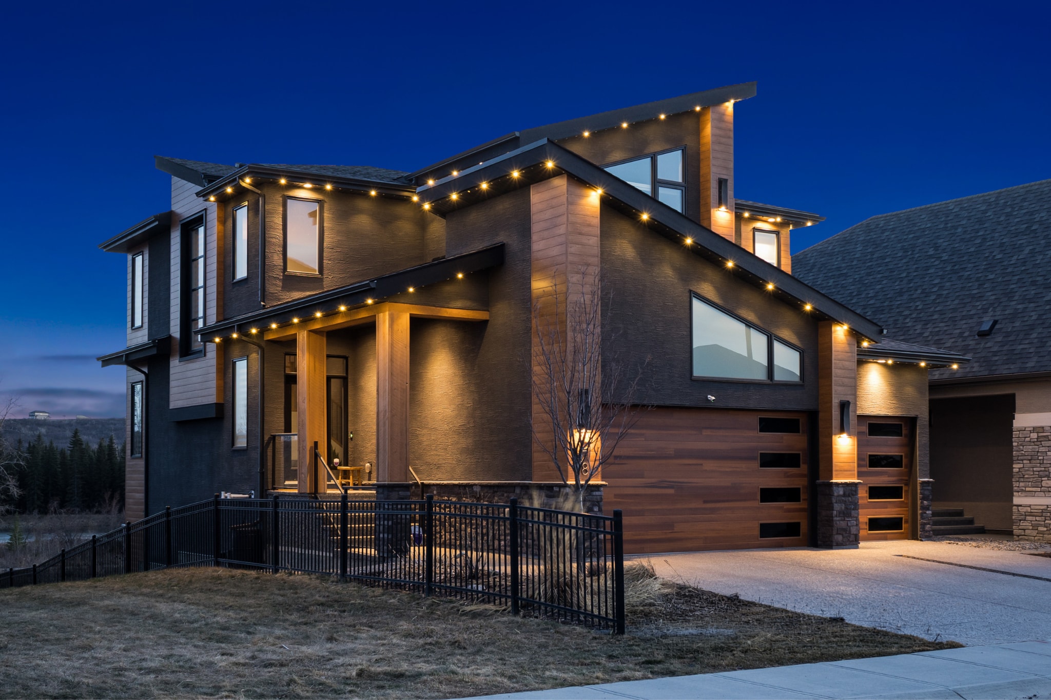 Modern home at dusk with warm architectural string lighting